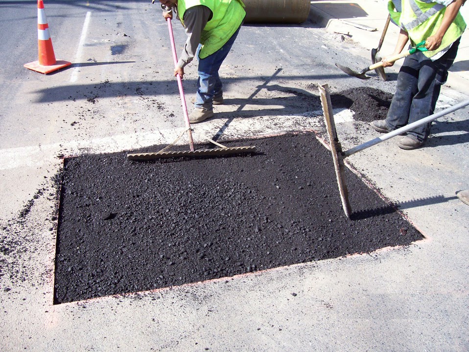 Asphalt Crew performing Asphalt Patching to a pot hole on a city road